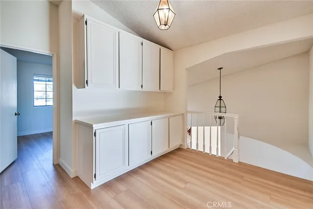 a kitchen with a refrigerator a stove cabinets and wooden floor