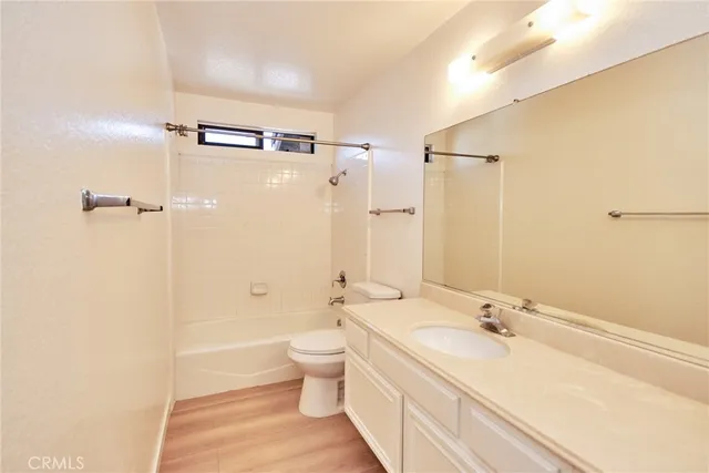 a bathroom with a granite countertop sink a toilet and shower