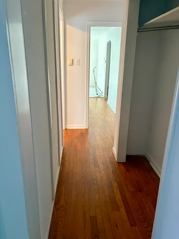 a view of empty room with wooden floor and cabinet