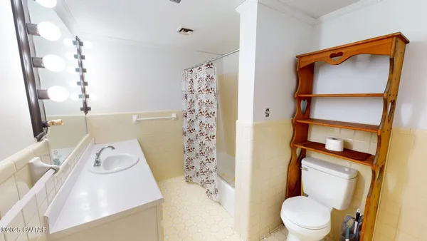 a white toilet sitting next to a bathroom sink and a shower