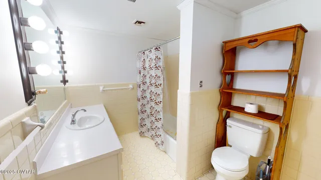 a white toilet sitting next to a bathroom sink and a shower