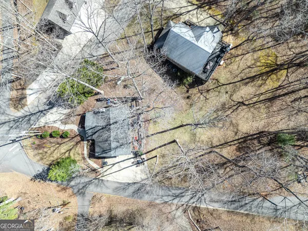 a view of a house next to a big yard and large trees