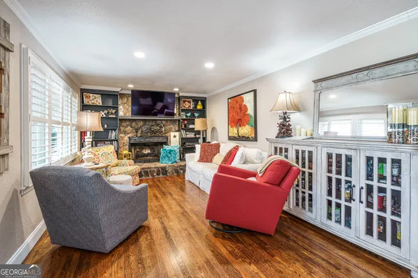 a living room with fireplace furniture and a wooden floor