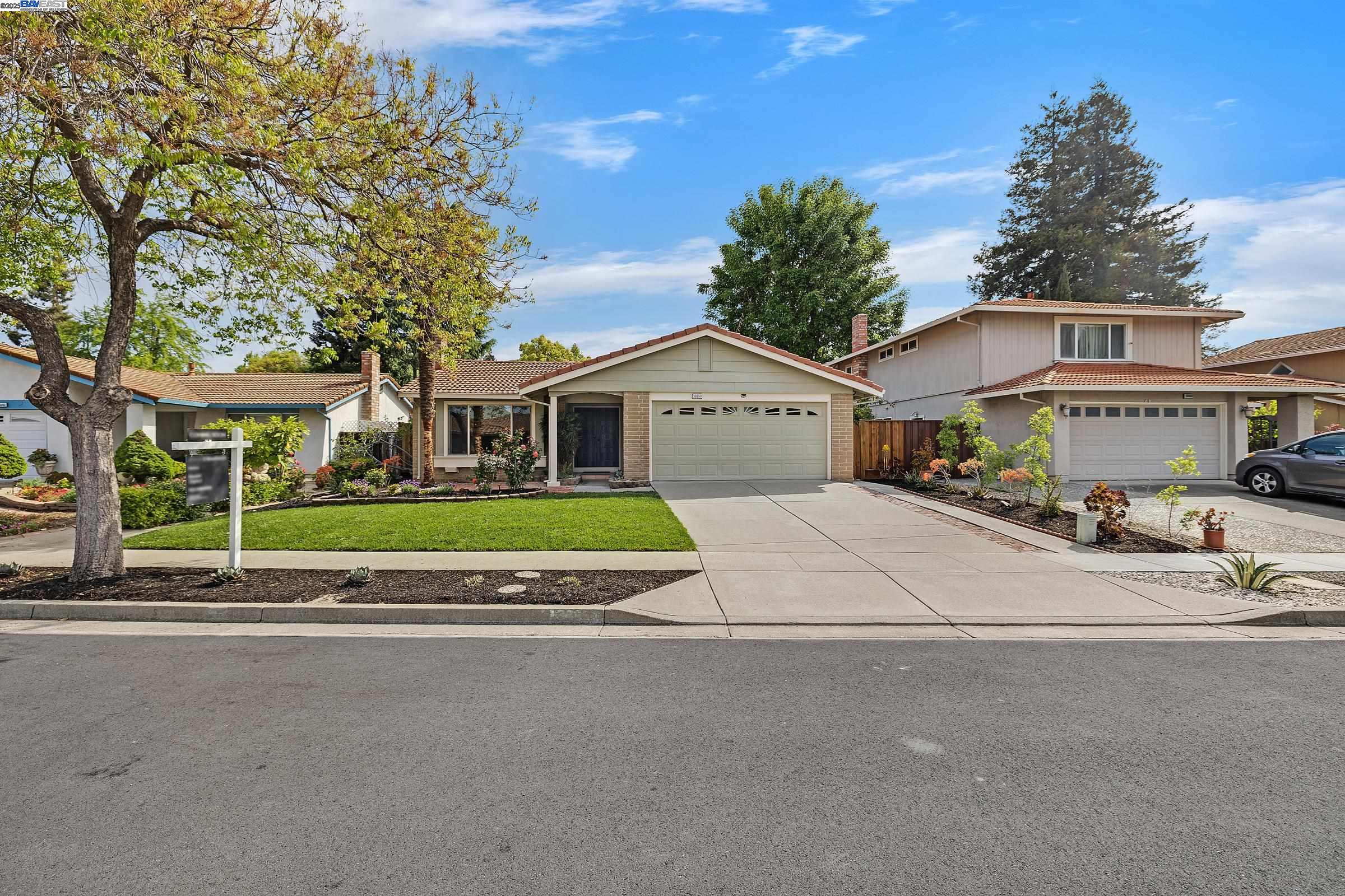 a view of a white house with a big yard and large trees