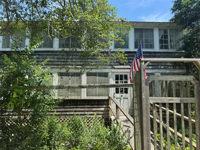 a view of a house with a small yard and potted plants