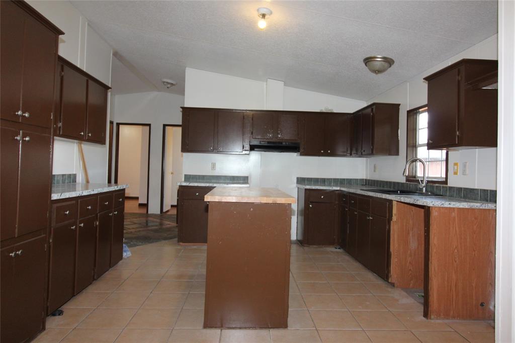 5199 Timarron Drive Scurry, TX 75158 - Photo 11 of 29 a large kitchen with stainless steel appliances granite countertop a refrigerator and a stove top oven