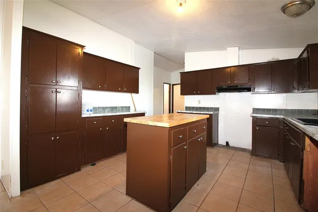 a kitchen with stainless steel appliances granite countertop a refrigerator and a stove