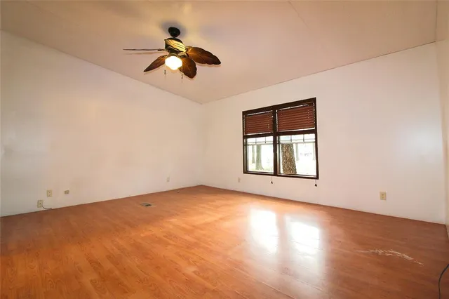 an empty room with a window and a ceiling fan