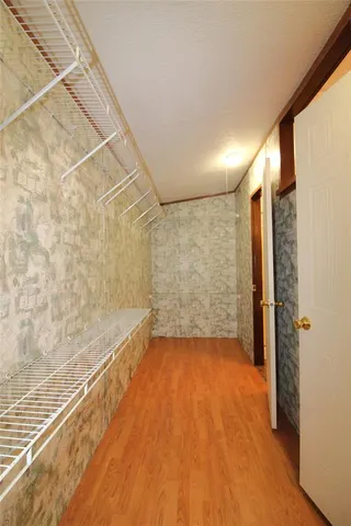 a view of a big room with wooden floor and brick walls