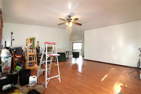 a view of a room with gym equipment and wooden floor