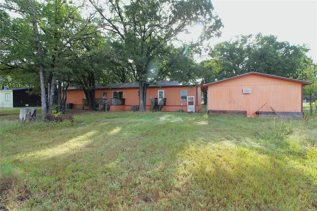 a view of a house with backyard and a tree