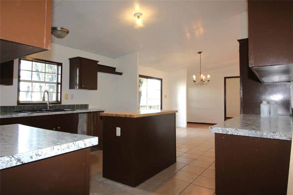 5199 Timarron Drive Scurry, TX 75158 - Photo 10 of 29 a kitchen with granite countertop a sink a stove and a refrigerator