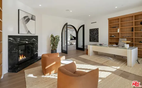 a living room with furniture a fireplace and a floor to ceiling window