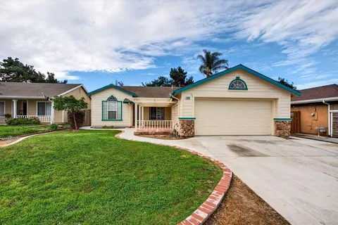 a front view of a house with a garden and yard