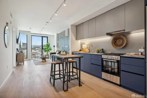 a open kitchen with stainless steel appliances granite countertop wooden floors a stove and a wooden floors