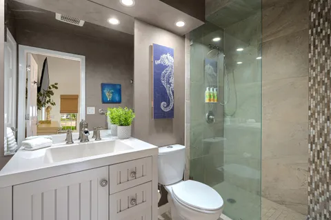 a bathroom with a double vanity sink toilet and shower