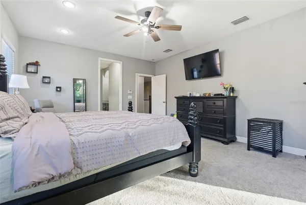 a bedroom with a bed a dresser and a flat screen tv