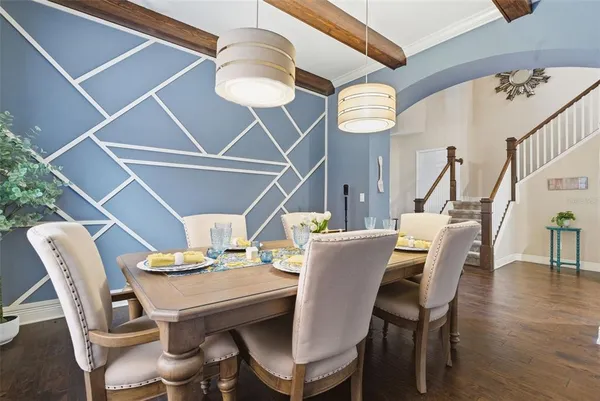 a dining room with furniture a chandelier and wooden floor