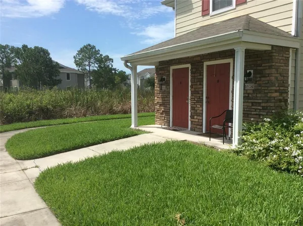 a view of a house with backyard and porch