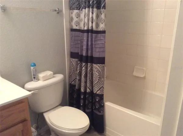 a white toilet sitting next to a bath tub