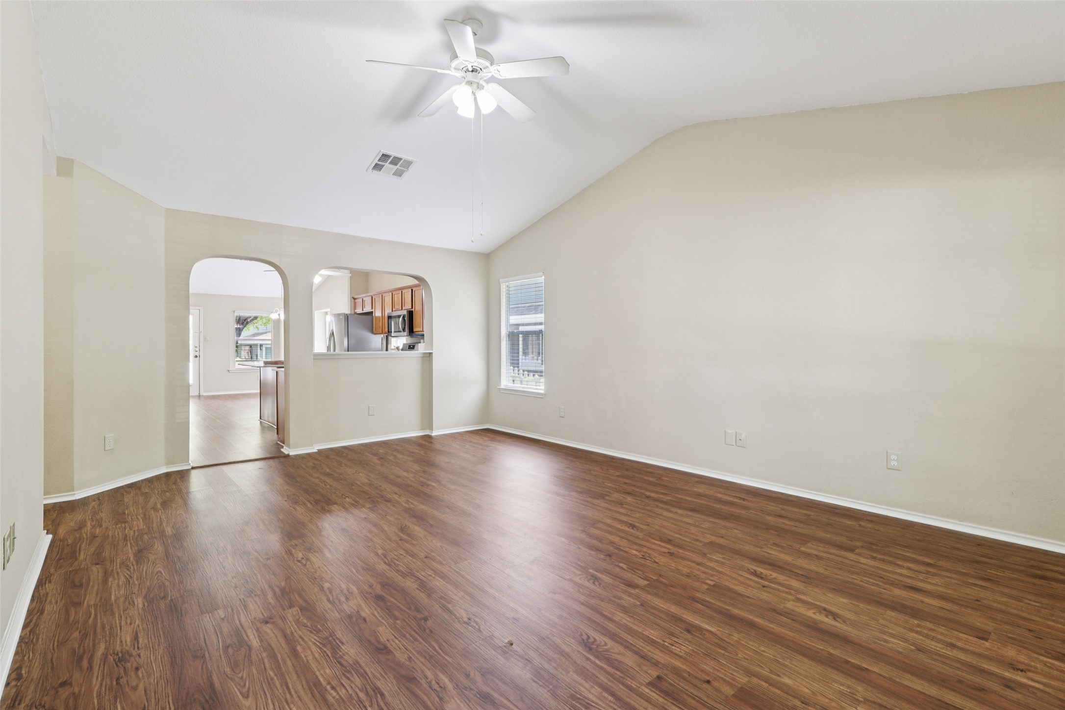 700 Scheel Road Kyle, TX 78640 - Photo 20 of 39 Spacious living area featuring vaulted ceilings, a ceiling fan, and rich wood-look flooring