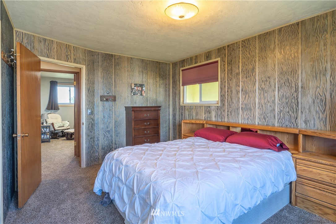 512 Rd P Northeast Moses Lake, WA 98837 - Photo 13 of 39 a bedroom with a large bed and a chandelier