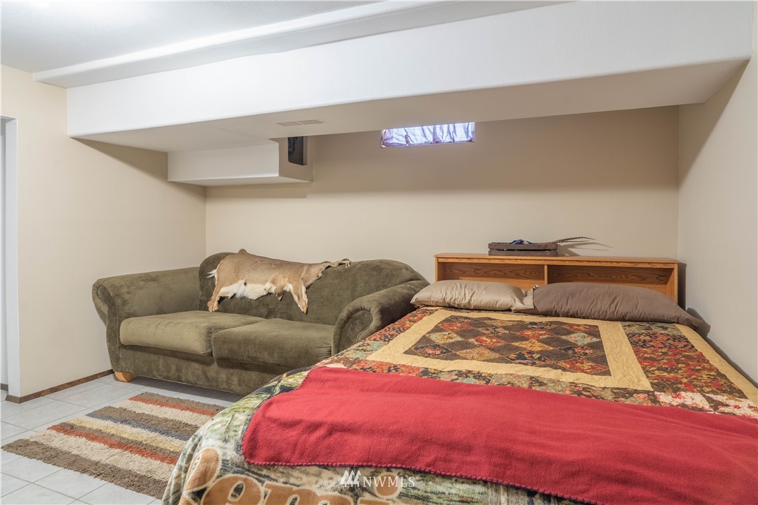 512 Rd P Northeast Moses Lake, WA 98837 - Photo 23 of 39 a bed sitting in a bedroom next to a lamp