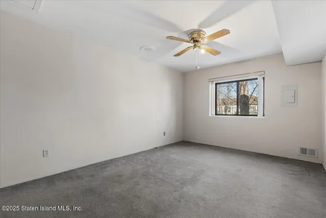an empty room with a window and a fan