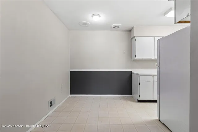 a view of an empty room with closet and a window