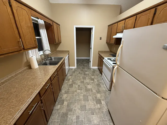 a kitchen with sink a refrigerator and microwave