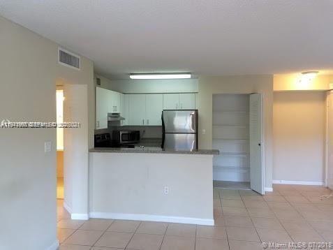 761 North Pine Island Road, Unit 203 Plantation, FL 33324 - Photo 2 of 11 a kitchen with stainless steel appliances a refrigerator and a sink