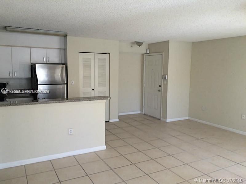 761 North Pine Island Road, Unit 203 Plantation, FL 33324 - Photo 3 of 11 a kitchen with white cabinets and refrigerator