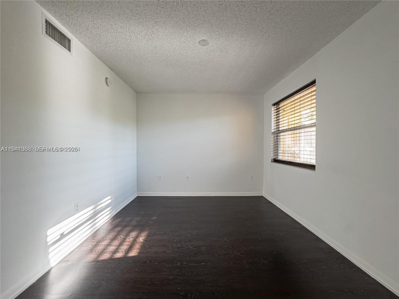761 North Pine Island Road, Unit 203 Plantation, FL 33324 - Photo 5 of 11 an empty room with wooden floor and windows