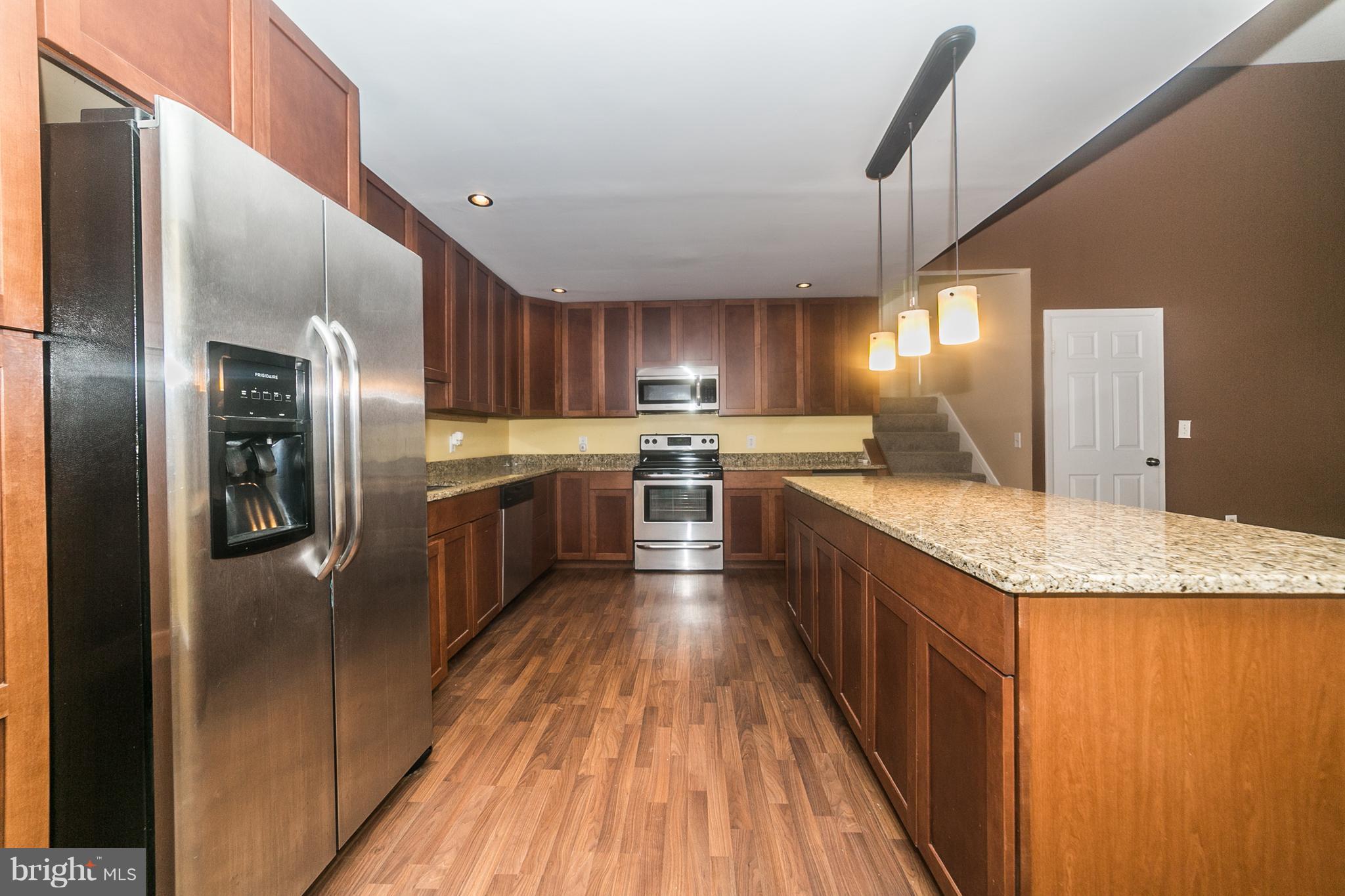 209 Redbud Road Edgewood, MD 21040 - Photo 9 of 30 a large kitchen with stainless steel appliances kitchen island granite countertop a large counter top and wooden floors