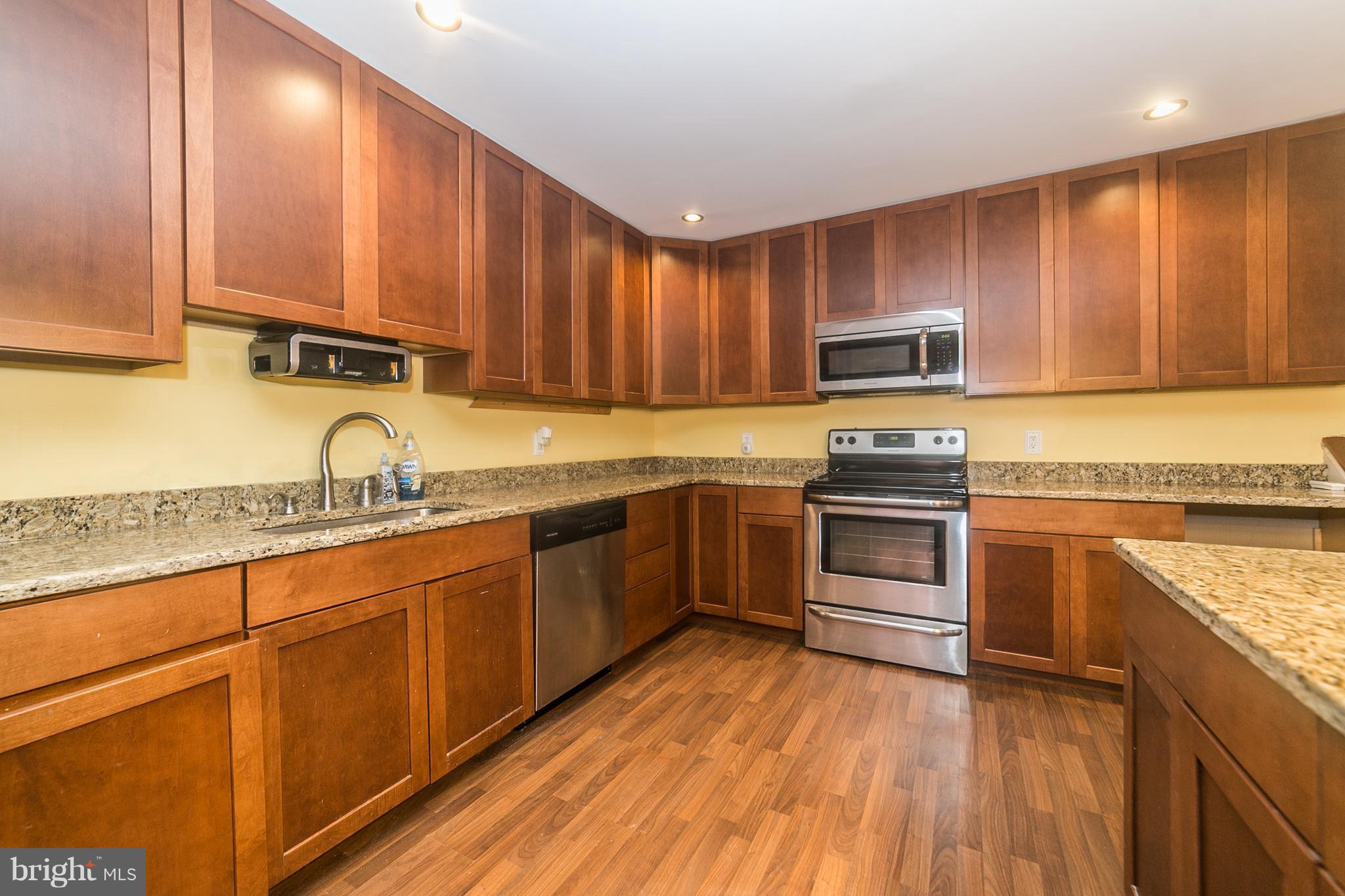 209 Redbud Road Edgewood, MD 21040 - Photo 10 of 30 a kitchen with granite countertop wooden cabinets a sink and dishwasher a stove with wooden floor