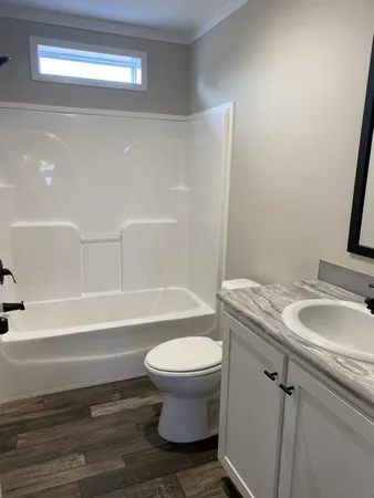 a bathroom with a granite countertop toilet and a sink