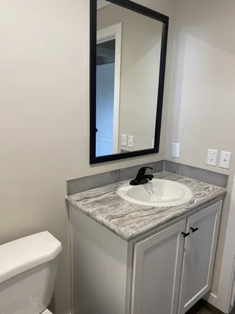 a bathroom with a granite countertop sink and a mirror