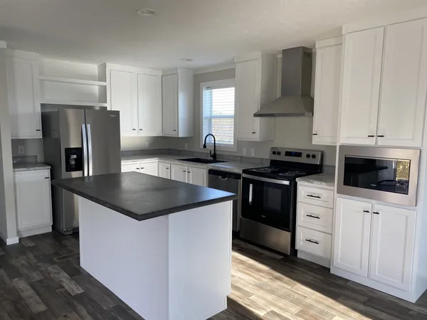 a kitchen with granite countertop a sink stove and refrigerator