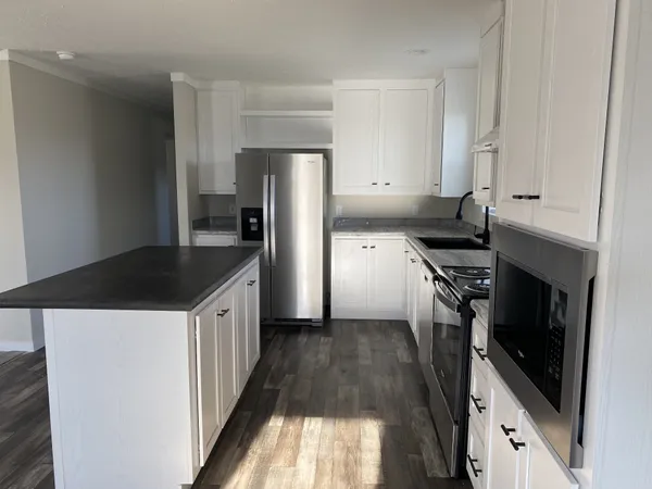 a kitchen with granite countertop a sink stove and refrigerator