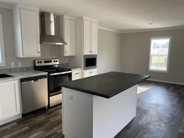 a kitchen with granite countertop a stove a sink and a microwave