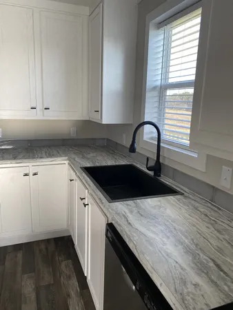 a kitchen with granite countertop a sink and a stove