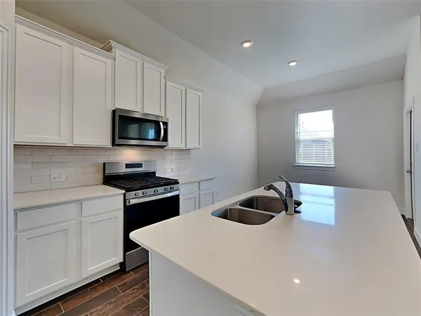 a kitchen with a sink a microwave and cabinets
