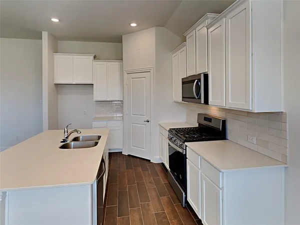 a kitchen with a sink a stove and cabinets