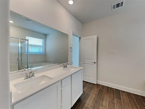 a bathroom with a sink double vanity granite tub shower and mirror
