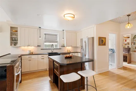 a kitchen with granite countertop a sink cabinets and refrigerator