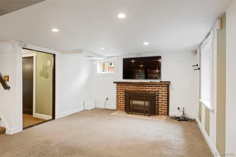 an empty room with kitchen and fireplace