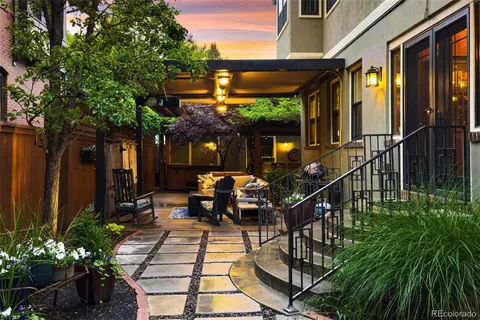 a view of house with patio outdoor seating and flowers