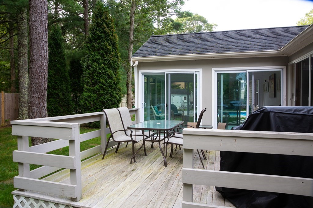 329 White Oak Trail Barnstable, MA 02632 - Photo 12 of 38 a view of a patio with table and chairs with wooden floor and fence