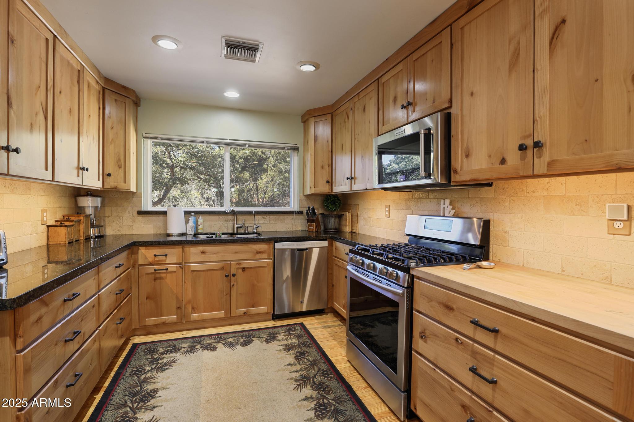 4744 Charles Circle Strawberry, AZ 85544 - Photo 13 of 39 a kitchen with stainless steel appliances granite countertop a stove a sink and a microwave