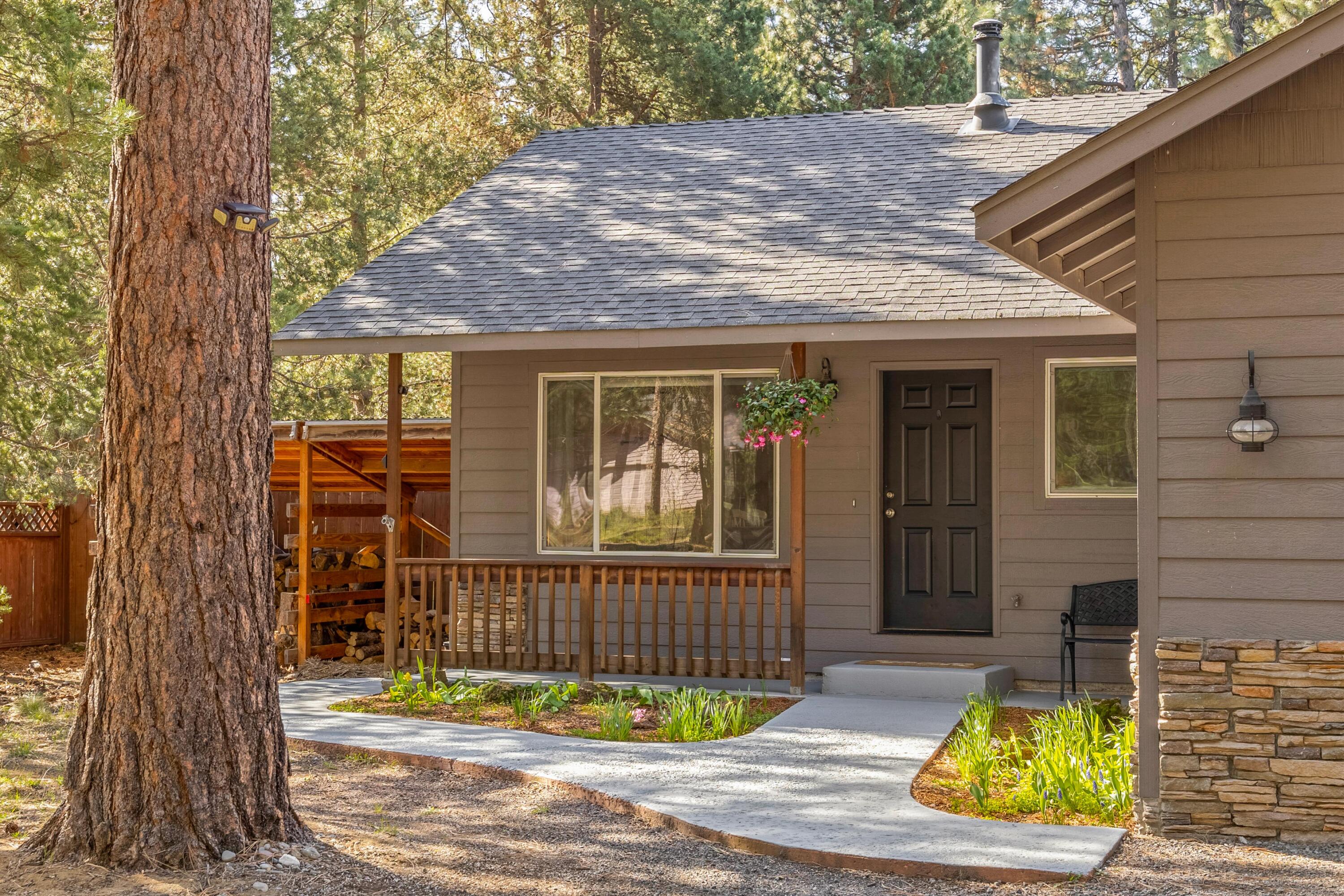 16983 Jacinto Road Bend, OR 97707 - Photo 6 of 29 a view of a brick house with a small yard and large tree